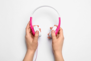 Woman holding stylish headphones on white background, closeup