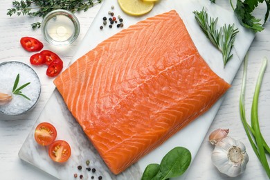 Fresh raw salmon and ingredients for marinade on white wooden table, flat lay