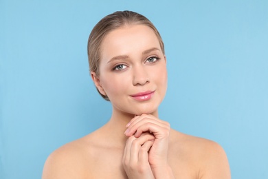 Photo of Portrait of young woman with beautiful face on blue background