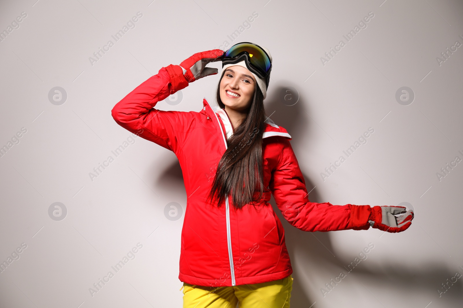 Photo of Woman wearing stylish winter sport clothes on light grey background