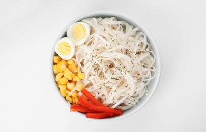 Photo of Bowl with rice noodles, egg and vegetables on white background, top view