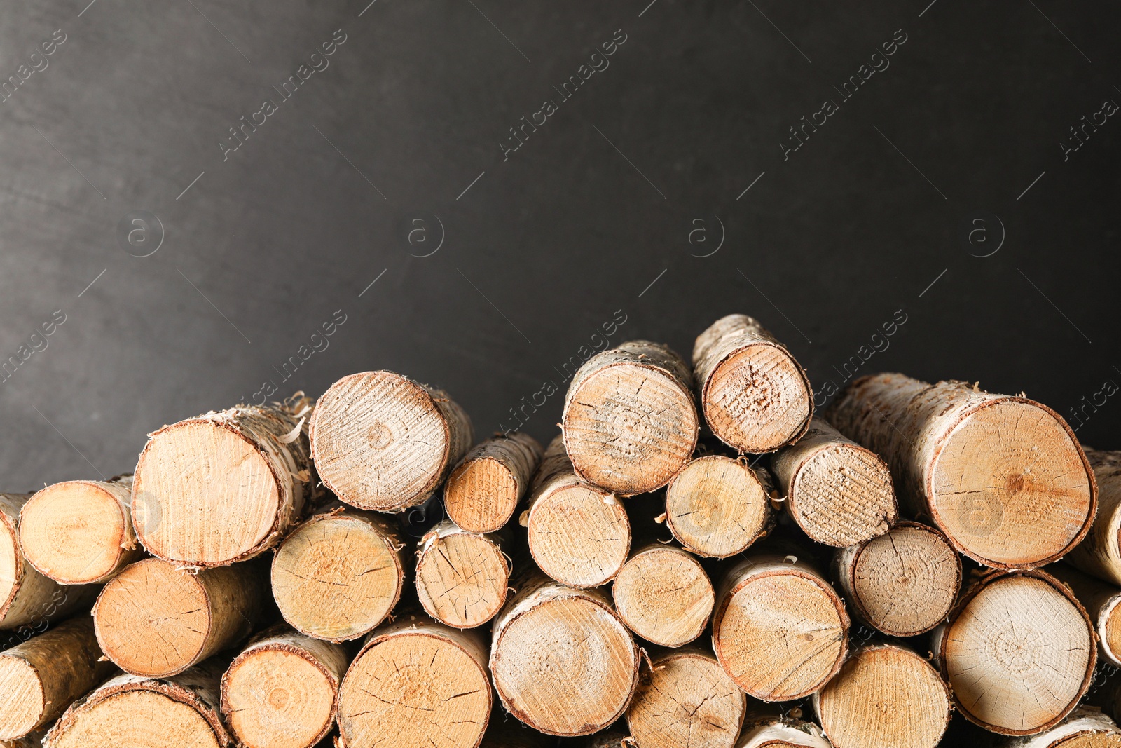 Photo of Cut firewood on black background. Heating in winter