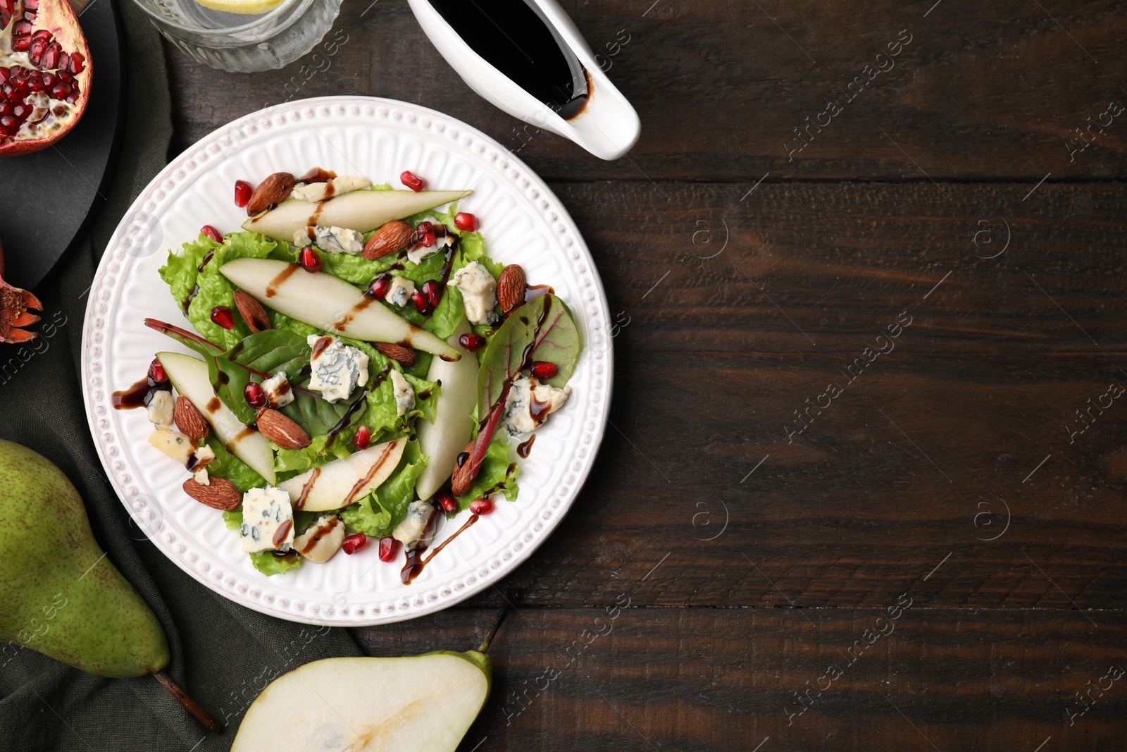 Photo of Delicious pear salad with sauce on wooden table, flat lay. Space for text