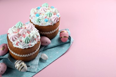 Photo of Traditional Easter cakes with meringues and painted eggs on pink background. Space for text