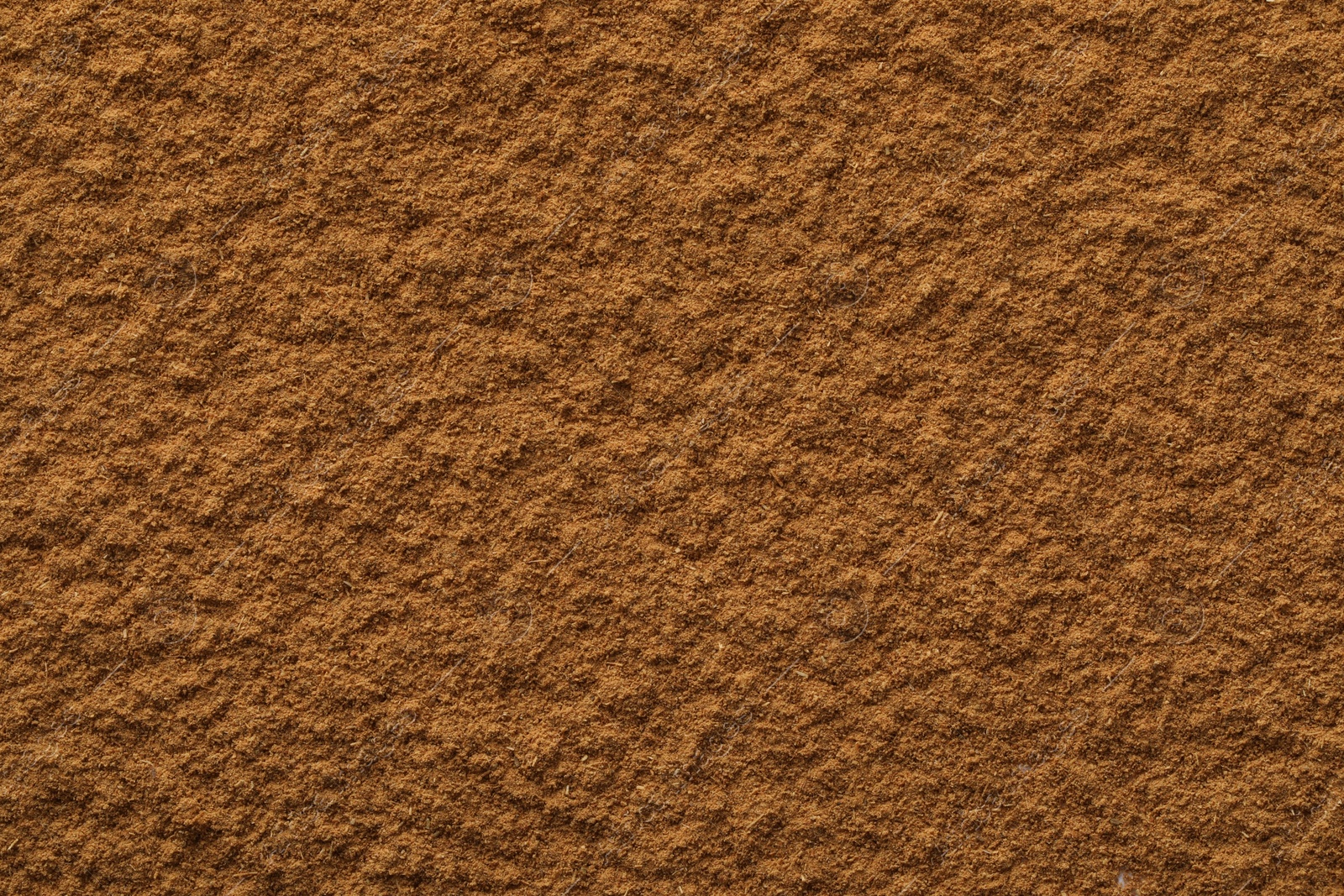 Photo of Dry aromatic cinnamon powder as background, top view