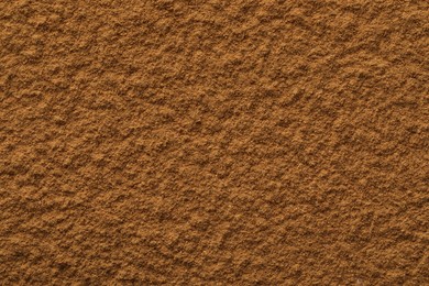 Dry aromatic cinnamon powder as background, top view