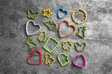 Photo of Set of different cookie cutters on grey table, flat lay. Cooking utensils