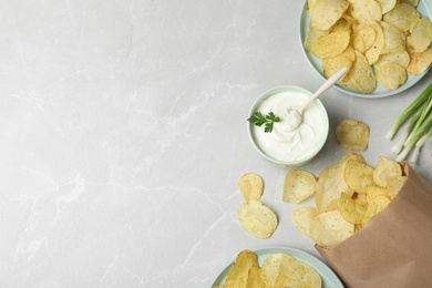 Sour cream and chips on light grey table, flat lay. Space for text