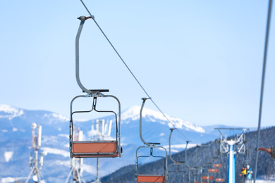 Empty chairlift at mountain ski resort, space for text. Winter vacation