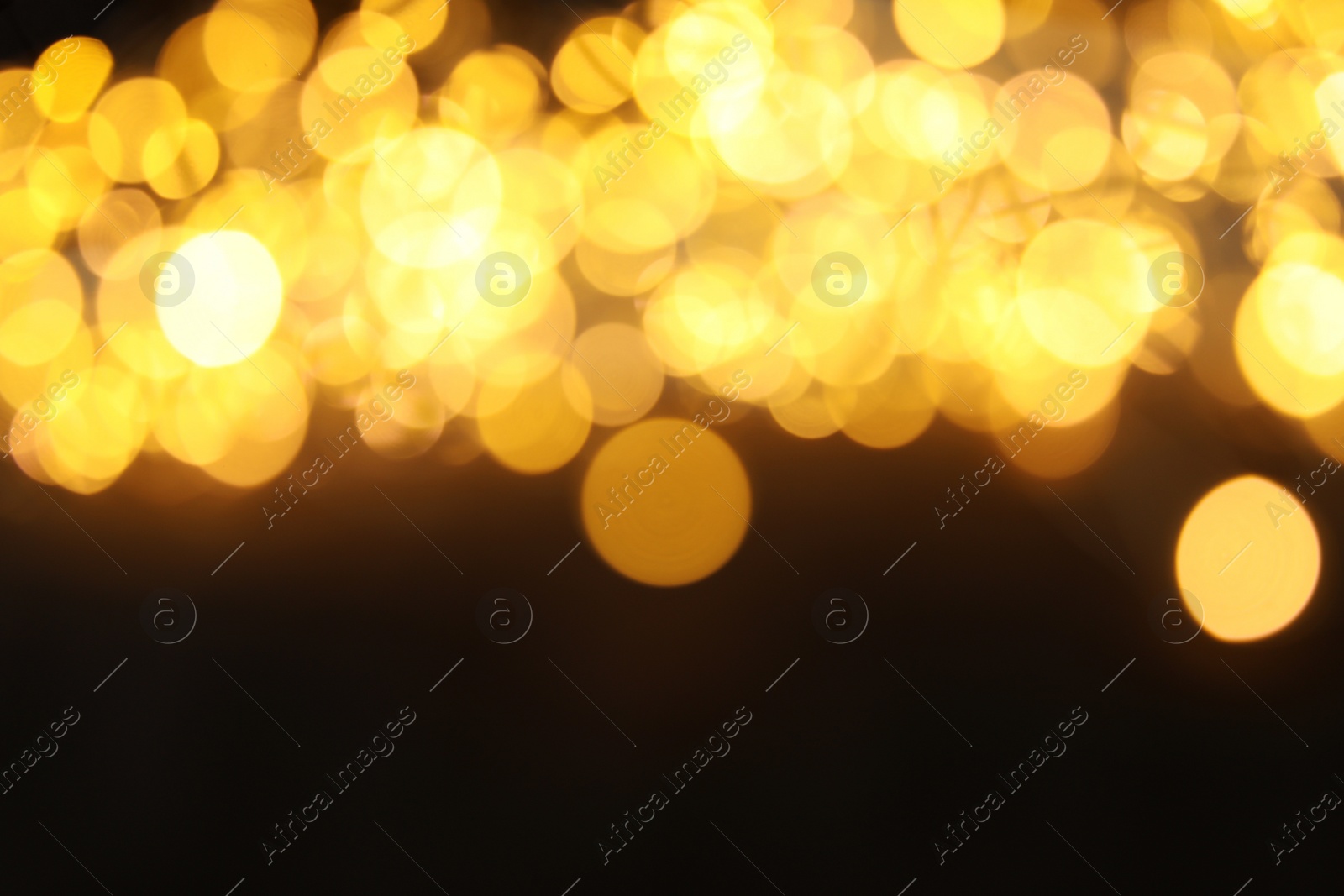 Photo of Gold glitter with bokeh effect on dark background