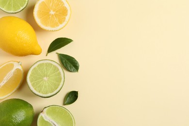 Photo of Fresh ripe lemons, limes and green leaves on beige background, flat lay. Space for text