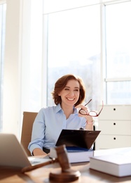 Female lawyer working at table in office
