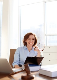 Photo of Female lawyer working at table in office