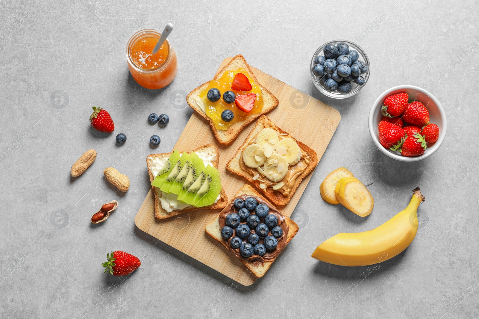 Photo of Flat lay composition with toast bread and different toppings on grey background