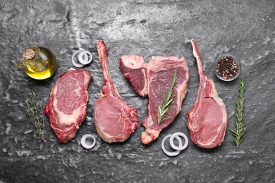 Fresh raw beef cuts and different spices on grey textured table, flat lay