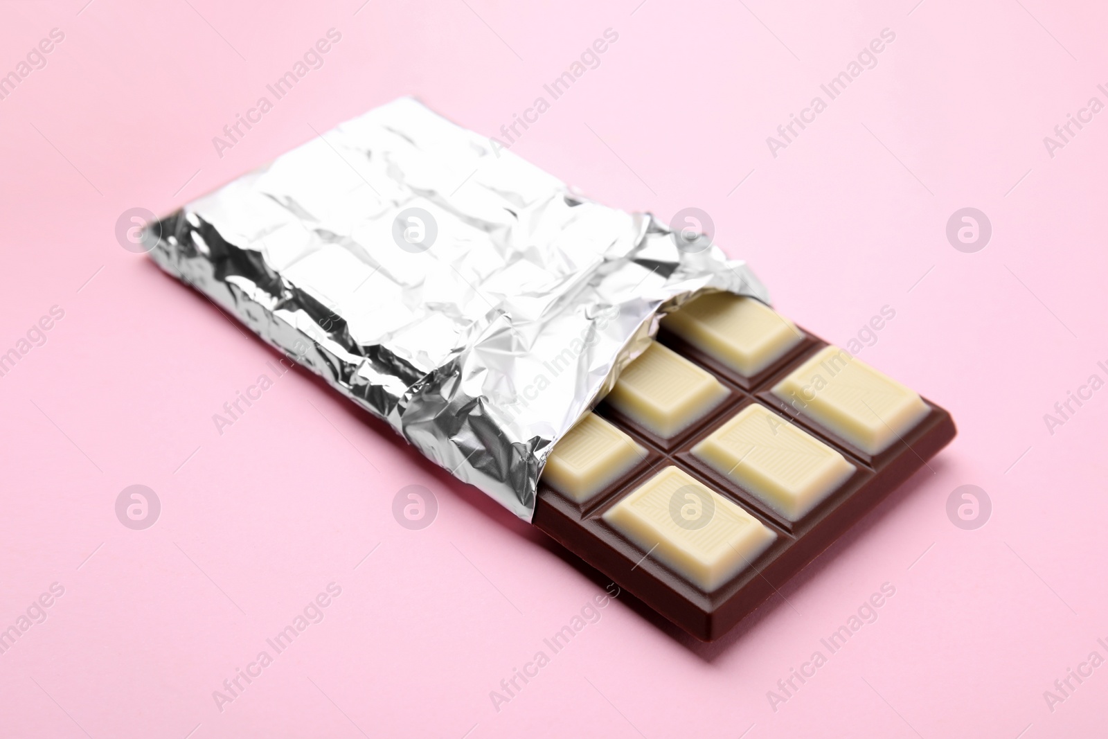 Photo of One tasty chocolate bar on pink background