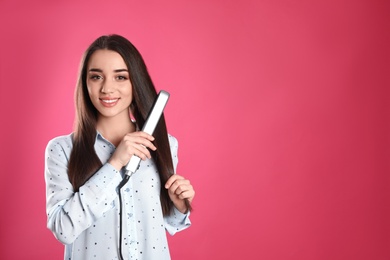 Photo of Happy woman using hair iron on color background. Space for text