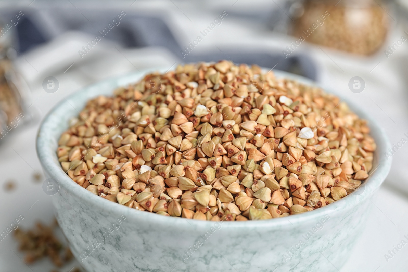 Photo of Bowl with organic green buckwheat on table, closeup view