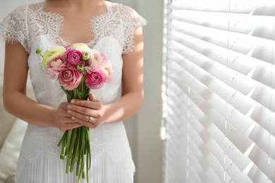 Photo of Bride with beautiful ranunculus bouquet indoors, closeup. Space for text