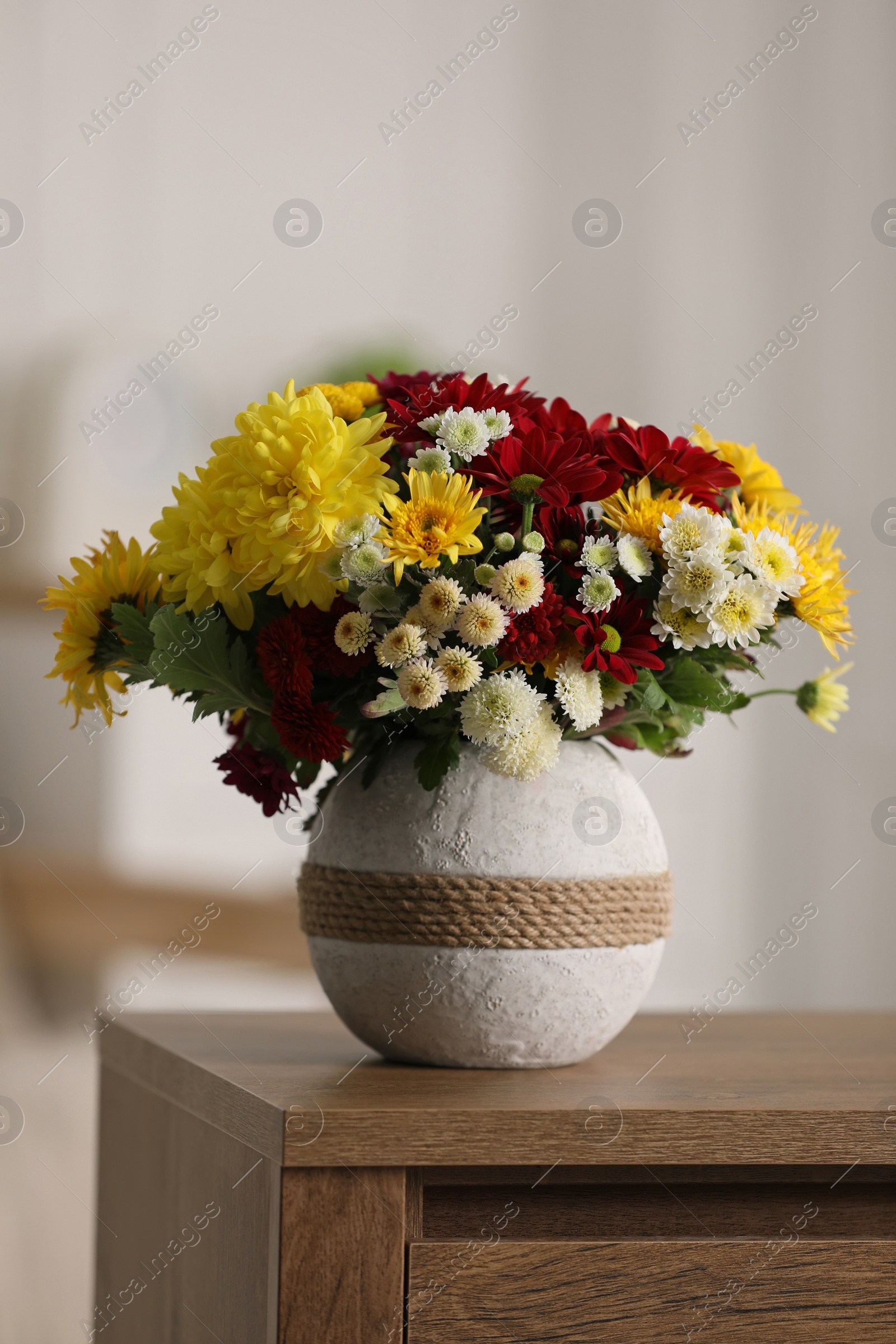 Photo of Bouquet of beautiful chrysanthemum flowers on table in room