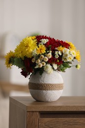 Photo of Bouquet of beautiful chrysanthemum flowers on table in room