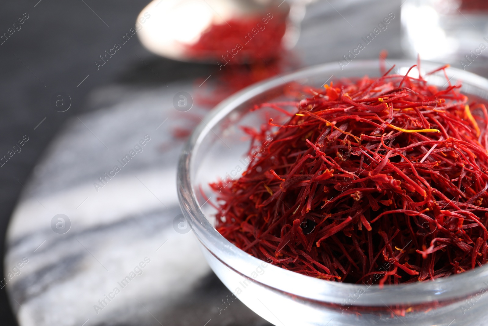 Photo of Dried saffron in glass bowl, closeup. Space for text
