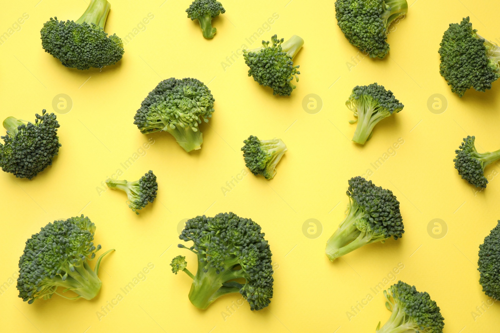 Photo of Fresh tasty broccoli on yellow background, flat lay