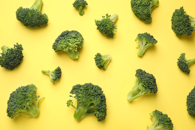 Photo of Fresh tasty broccoli on yellow background, flat lay