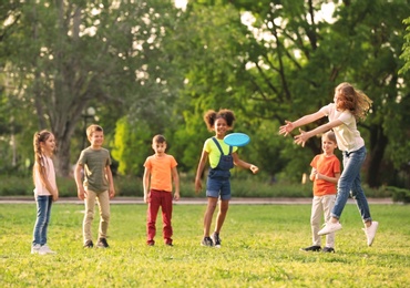 Cute little children playing with frisbee outdoors on sunny day