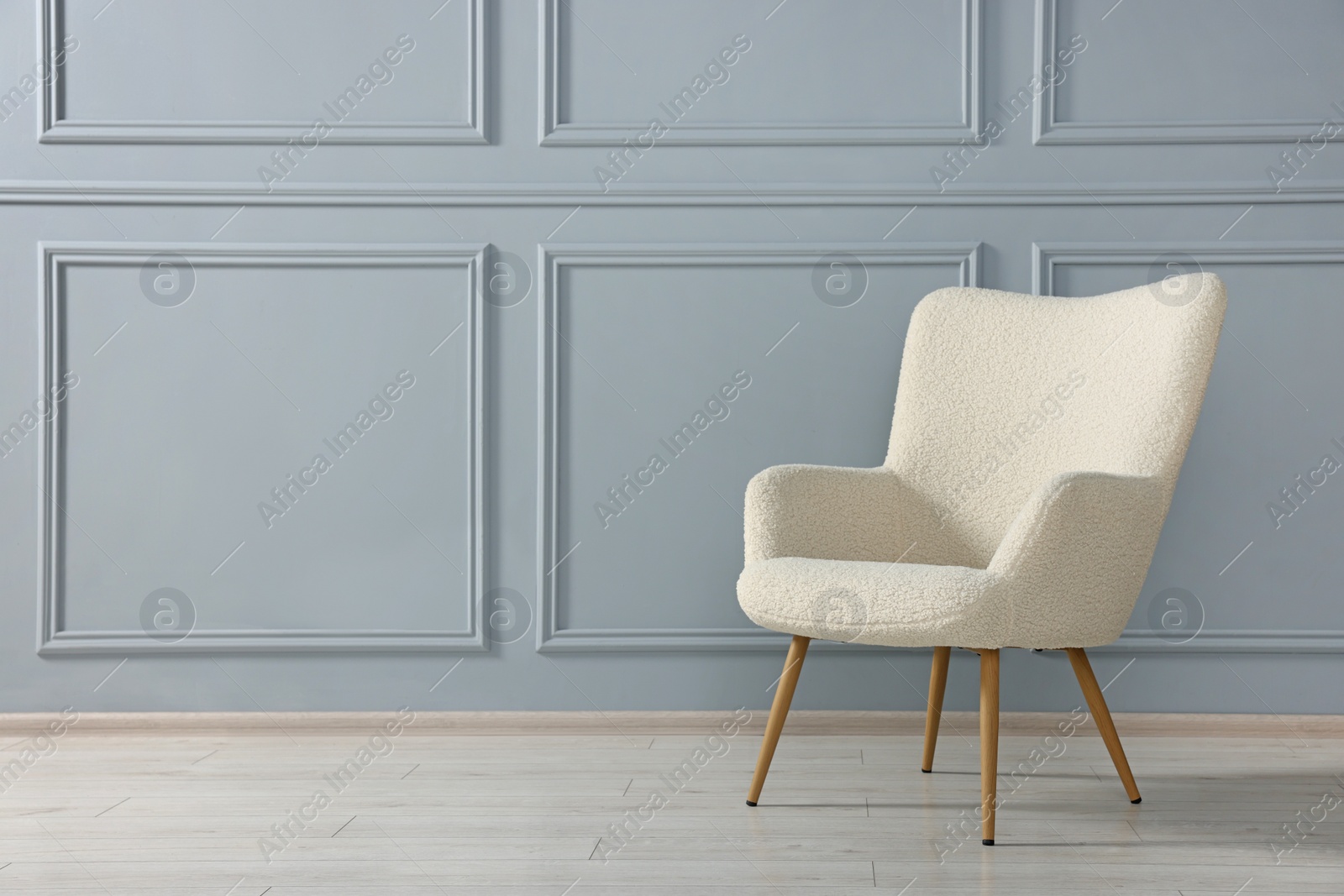 Photo of Comfortable armchair near light grey wall indoors. Space for text