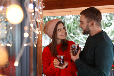 Photo of Lovely couple with tasty mulled wine in cafe. Winter vacation