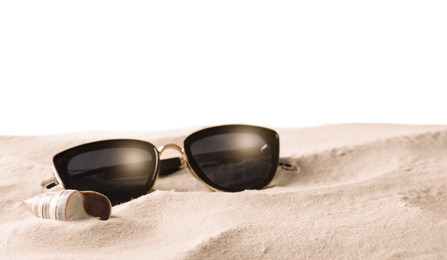 Photo of Stylish sunglasses and shell on sand against white background. Space for text