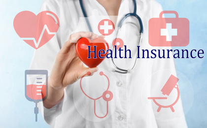 Image of Phrase Health Insurance, icons and doctor with heart model on light background
