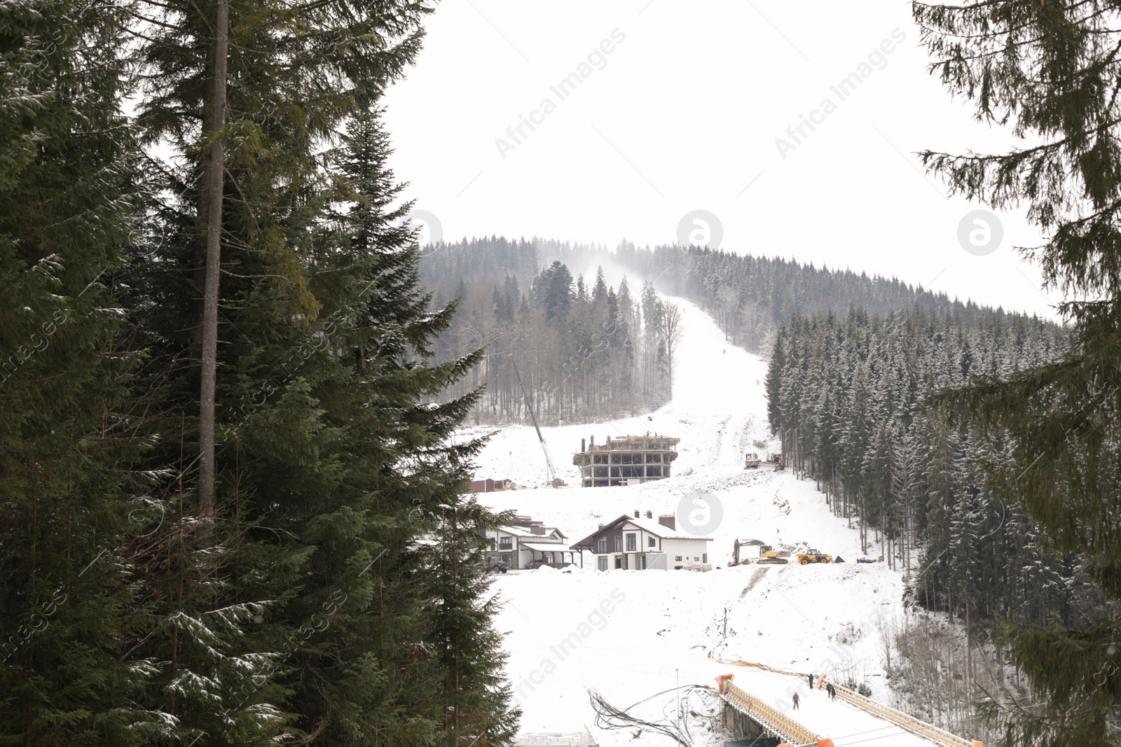Photo of Winter landscape with mountain village near conifer forest