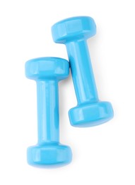 Photo of Light blue dumbbells isolated on white, top view. Sports equipment