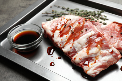 Photo of Fresh raw ribs on baking sheet, closeup