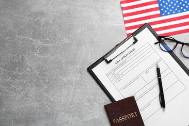 Photo of American flag, visa application form, passport and glasses on light grey table, flat lay. Space for text