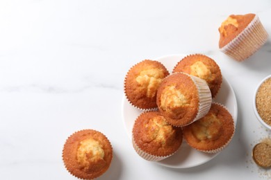 Photo of Delicious sweet muffins on white marble table, flat lay, Space for text