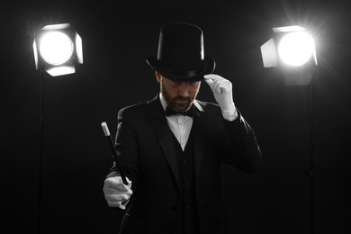 Magician wearing top hat and holding wand on stage
