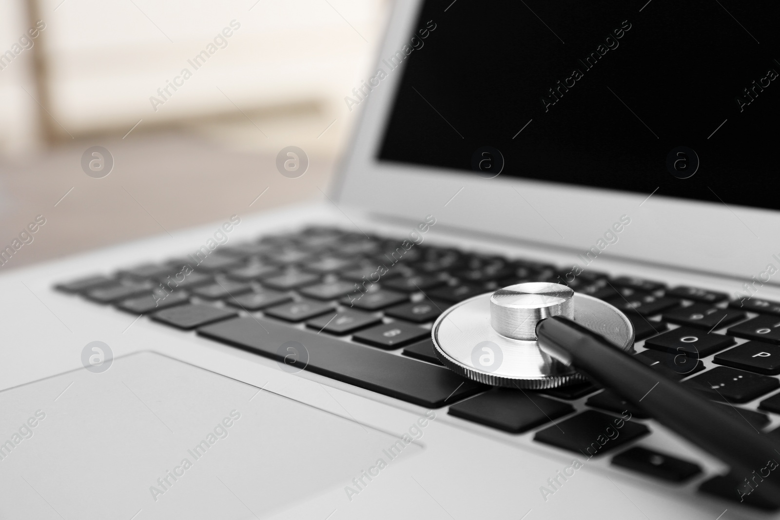 Photo of Modern laptop and stethoscope, closeup. Technical support concept