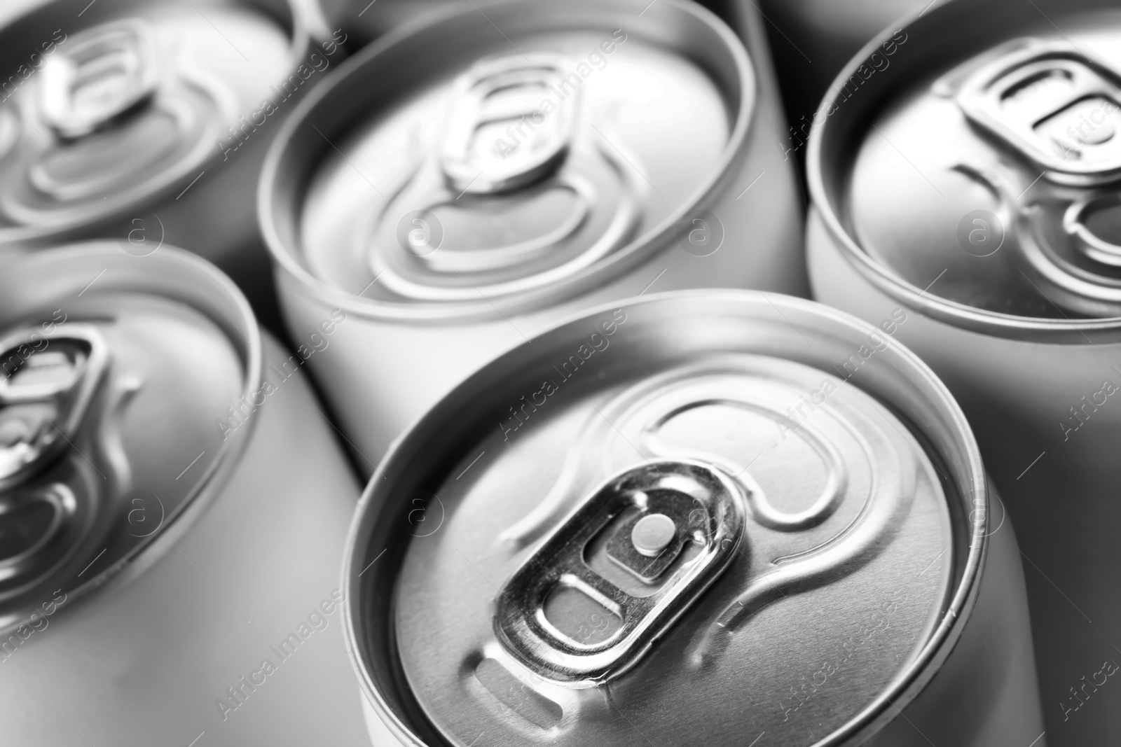 Photo of Aluminum cans with cold beverage as background, closeup