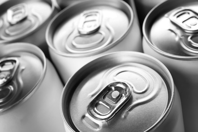 Photo of Aluminum cans with cold beverage as background, closeup