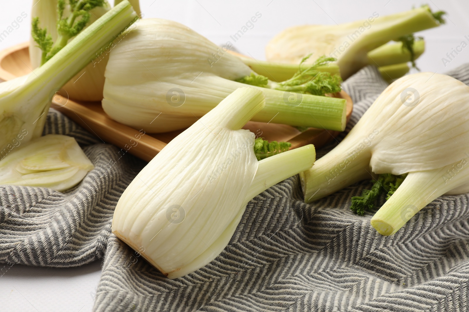 Photo of Whole and cut fennel bulbs on white table, closeup