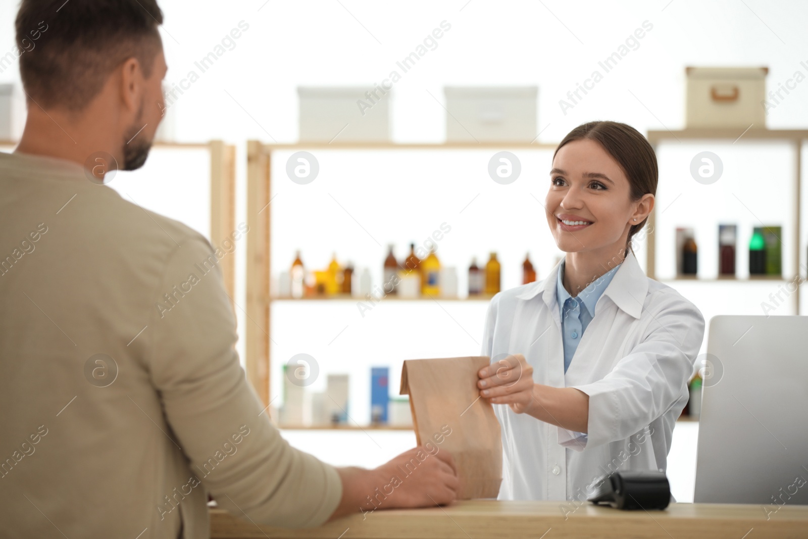 Photo of Pharmacist giving medicine to customer in drugstore