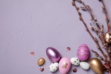 Photo of Flat lay composition with festively decorated Easter eggs and pussy willow branches on grey background. Space for text