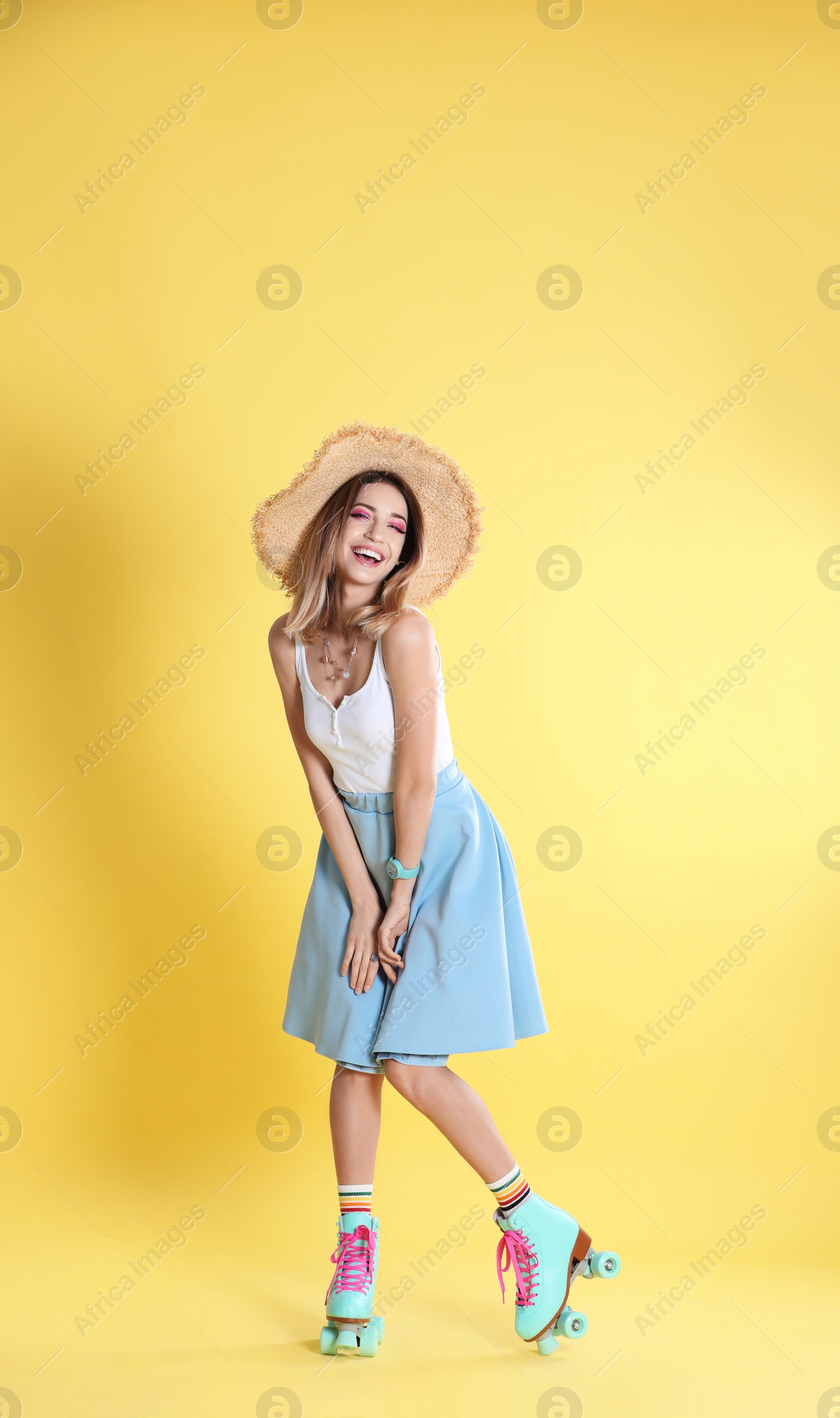 Photo of Young woman with retro roller skates on color background