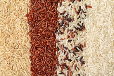 Photo of Brown and other types of rice as background, closeup