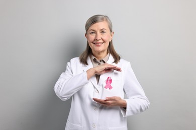 Mammologist with pink ribbon on gray background. Breast cancer awareness