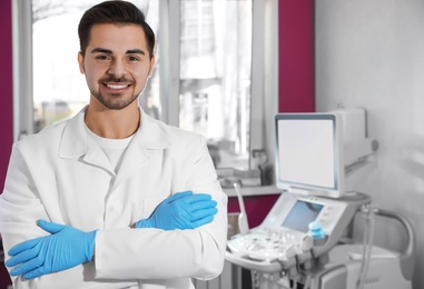 Photo of Sonographer near modern ultrasound machine in clinic, space for text