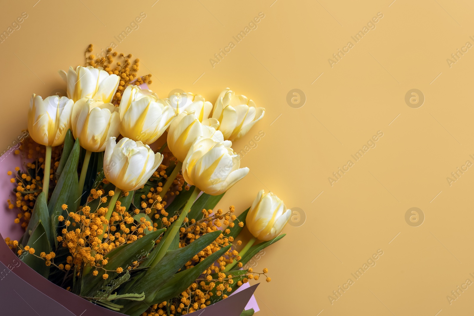 Photo of Bouquet with beautiful tulips and mimosa flowers on yellow background, top view. Space for text